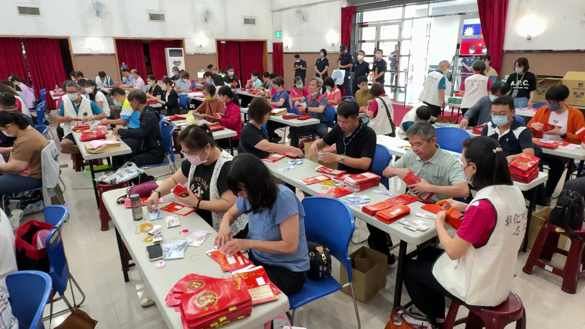 ▲為了發放全市的重陽敬老禮金，市公所動員近百名人力進行清點與裝入紅包袋。（記者張溎壕攝）